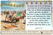 Die lustige Einladung zum Geburtstag - Die sichtlich vom Alter geschaffte Frau im Liegestuhl am Strand mit einem Glas Rotwein auf dem Bauch